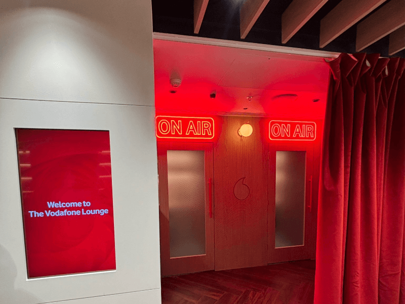 Vodafone Lounge recording booths with red neon ON AIR signs and a Welcome to The Vodafone Lounge screen