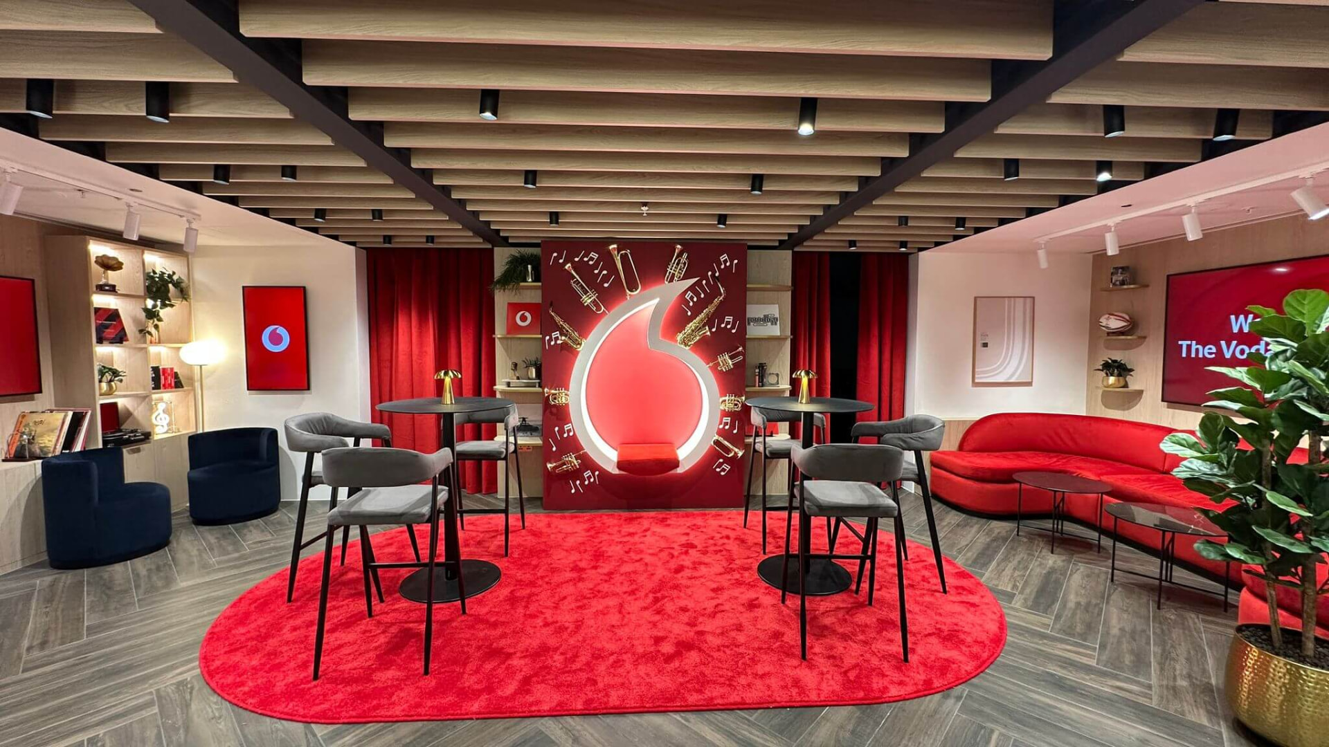 Vodafone Lounge at Co-op Live with red seating, illuminated branding and bespoke fitted displays