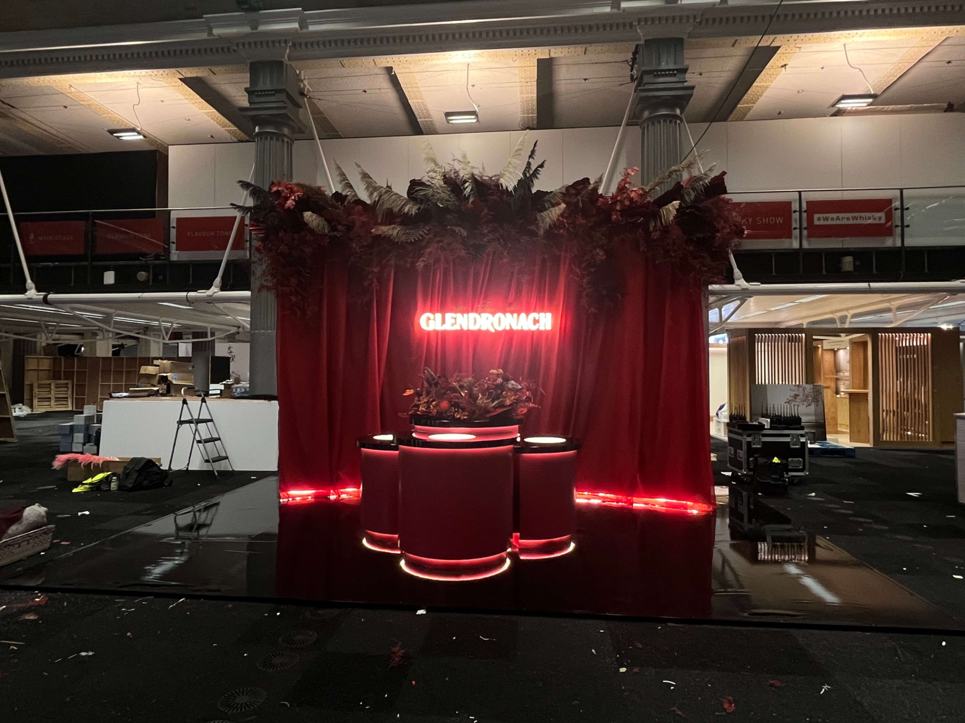 Glendronach exhibition stand with a red illuminated tasting counter and floral canopy
